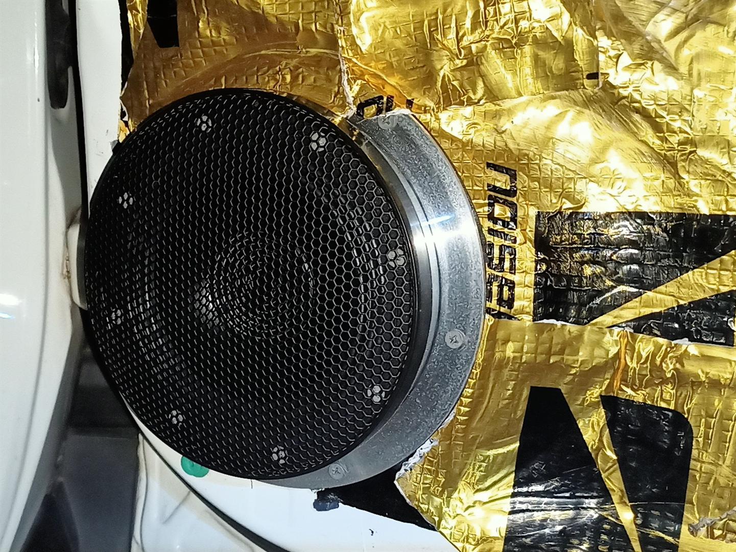 Speaker midrange terpasang di pintu mobil dengan latar peredam goldfoil — instalasi audio mobil Kalimantan Selatan